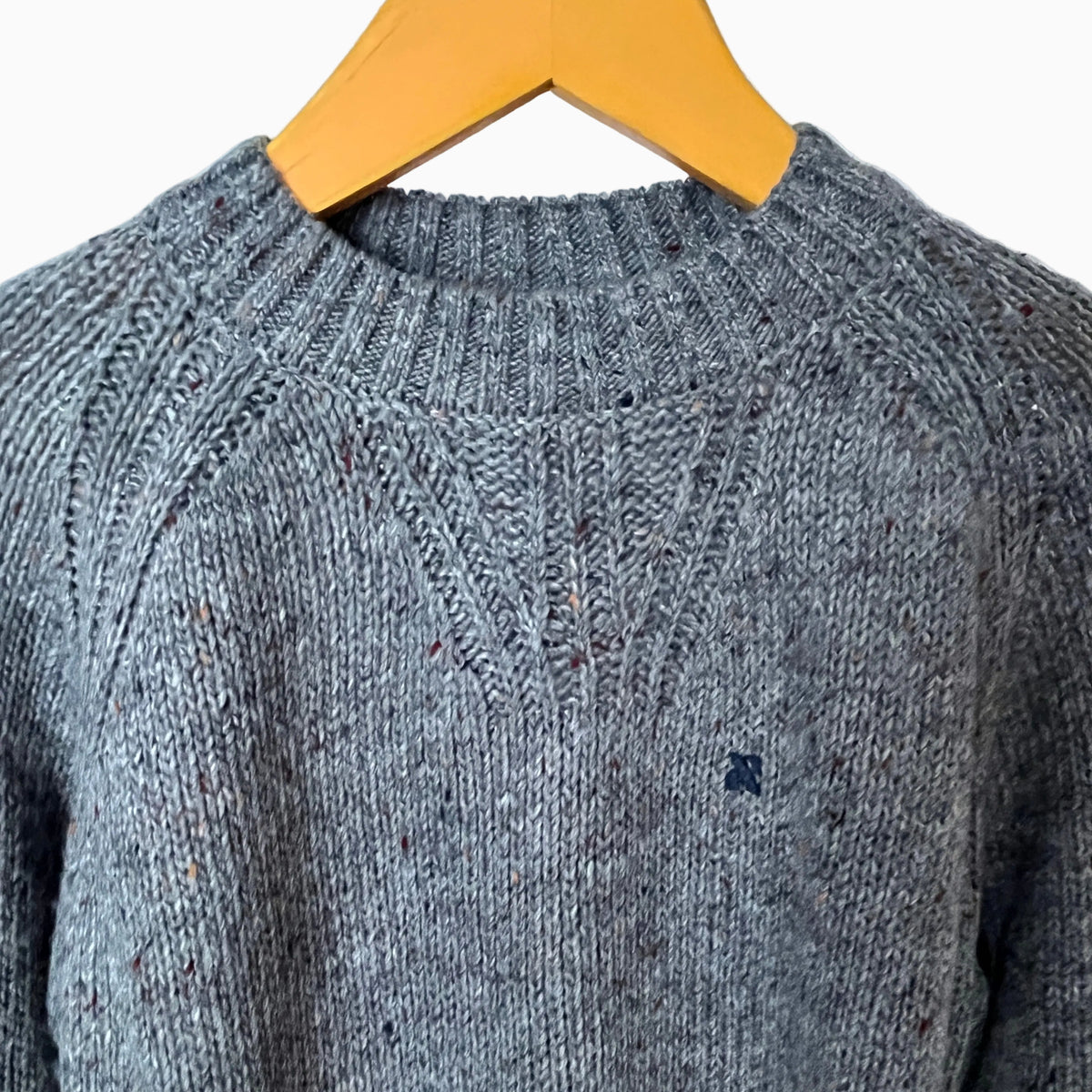 Dettaglio trama maglia melange e logo ricamato blu su maglione bambino Mayoral