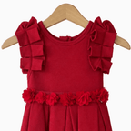 Dettaglio spalline geometriche e fiori tridimensionali su cintura abito rosso bambina