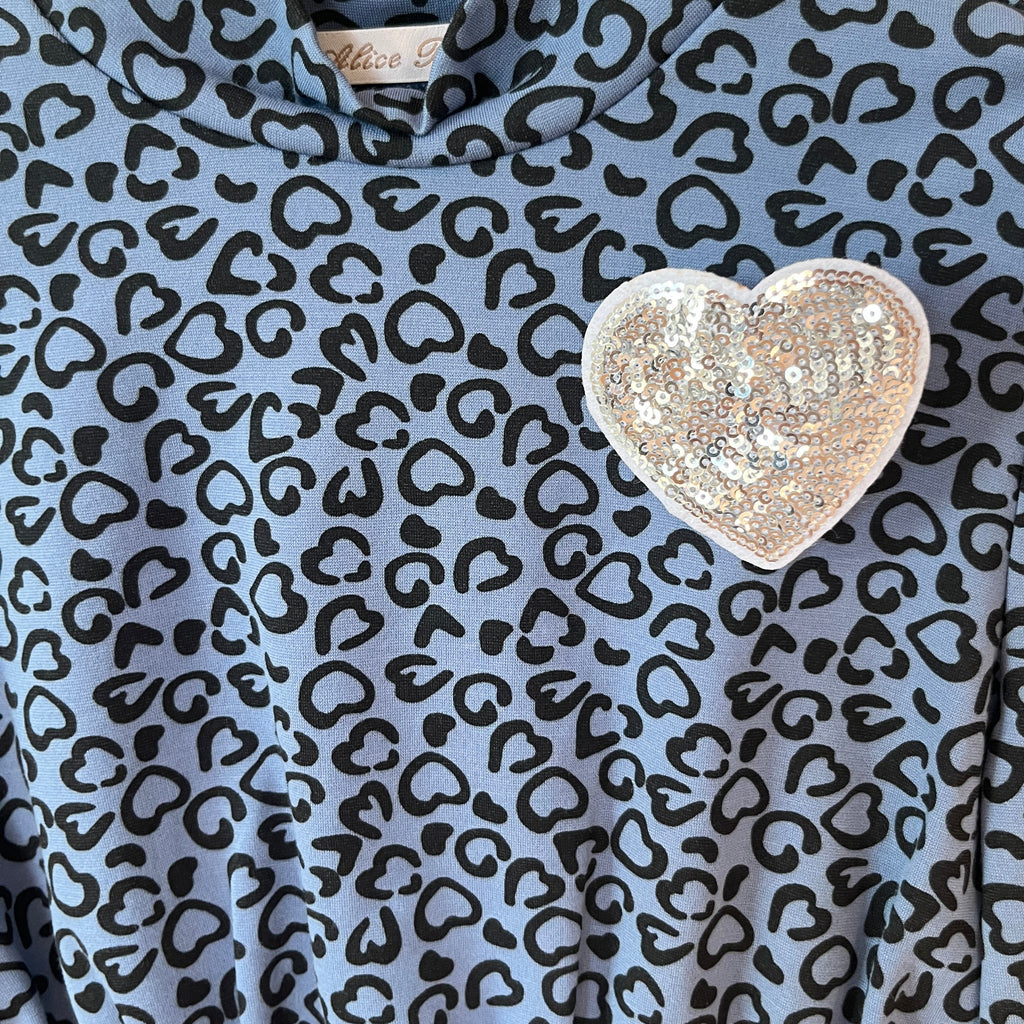 Dettaglio spilla cuore paillettes argento top bambino azzurro tessuto stampato