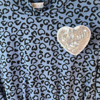 Dettaglio spilla cuore paillettes argento top bambino azzurro tessuto stampato