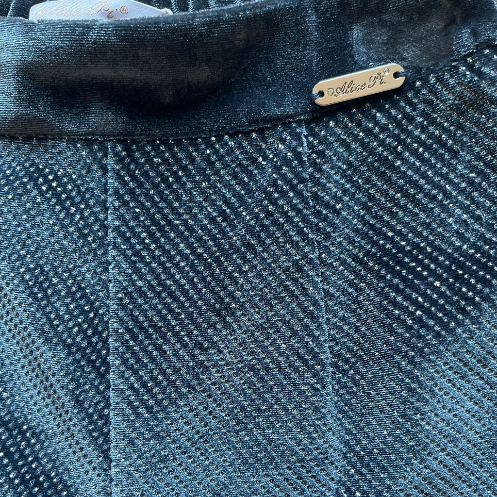 Dettaglio tessuto effetto metallizzato e logo Alice Pi su vita in velluto pantaloni
