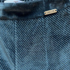 Dettaglio tessuto effetto metallizzato e logo Alice Pi su vita in velluto pantaloni