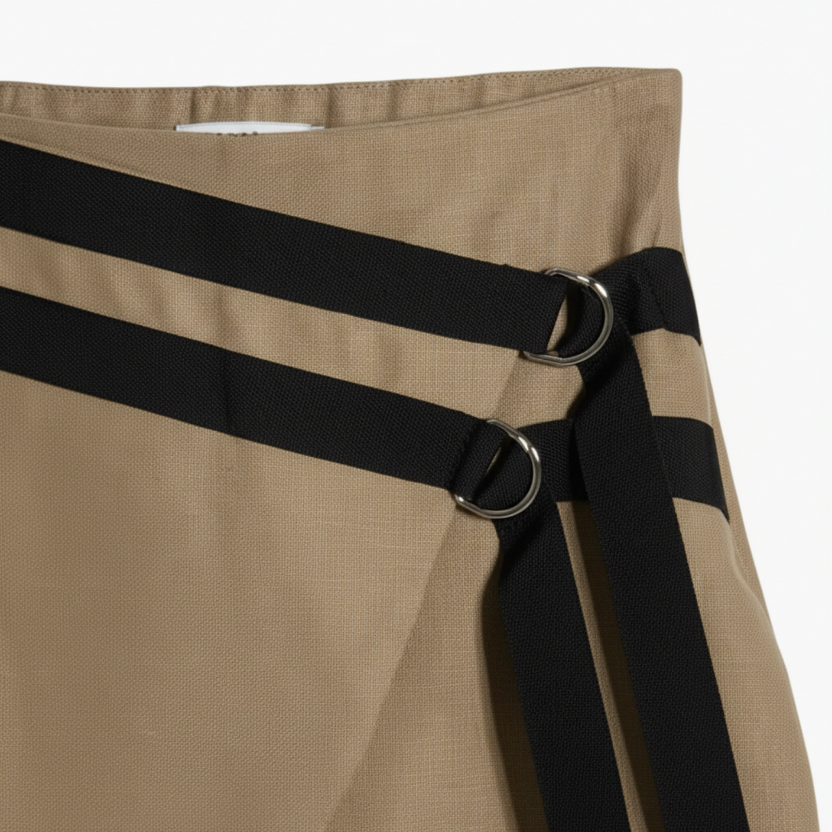 Dettaglio tessuto gonna beige bambina con fibbie decorative nere